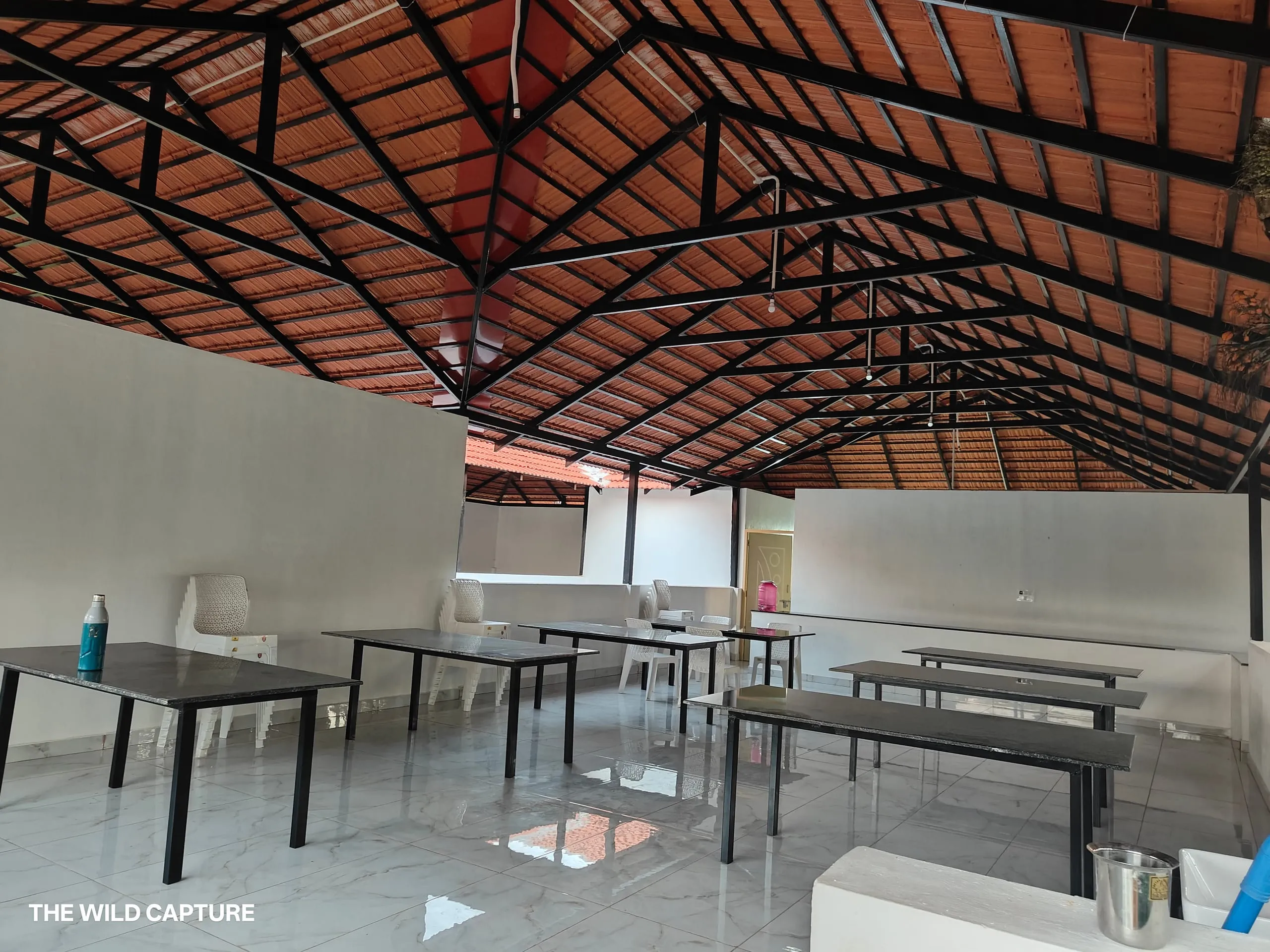Wide view of the dining hall showing the tiled roof and seating for large groups