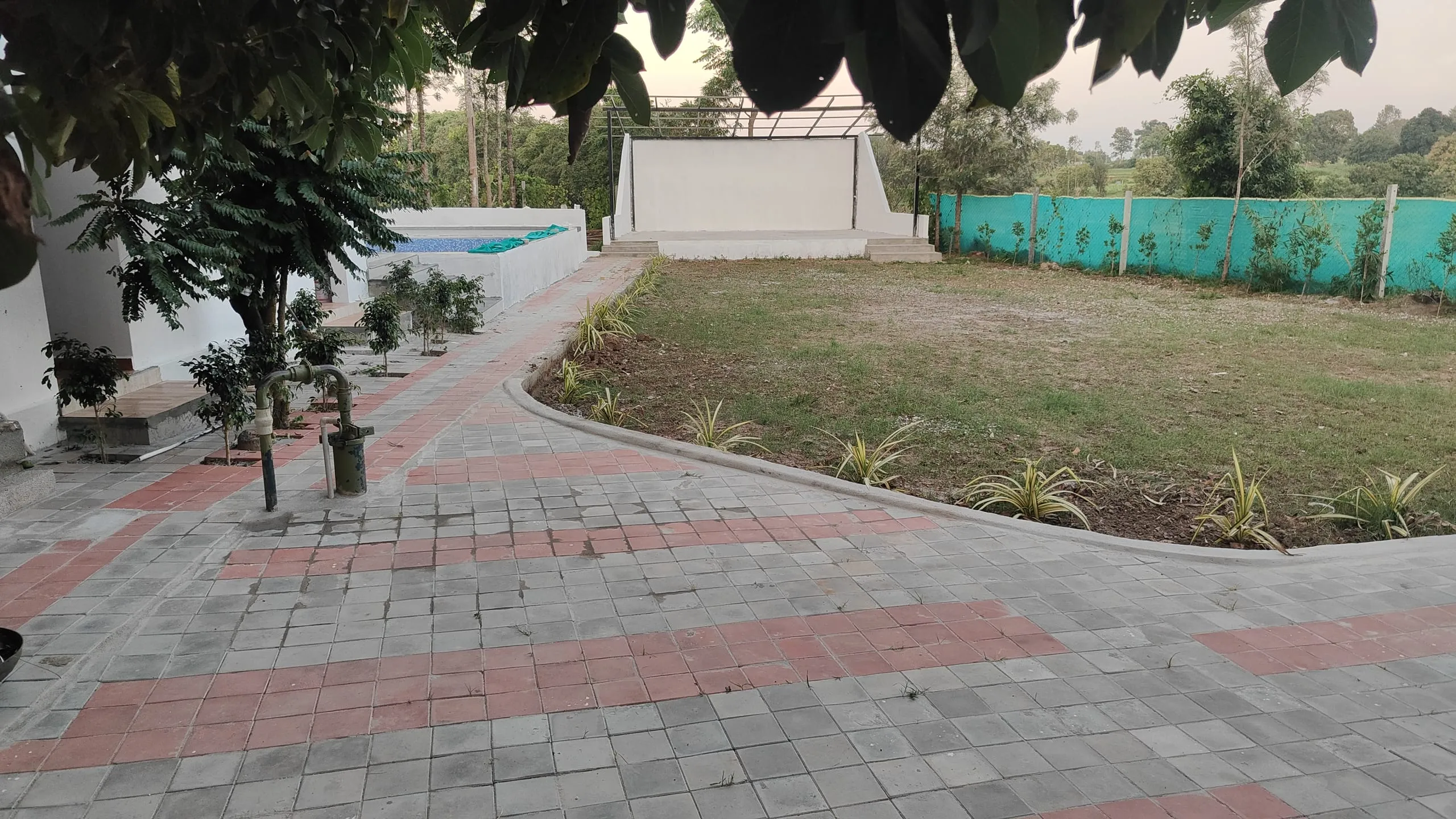 The lawn and open-air stage with the pool beyond
