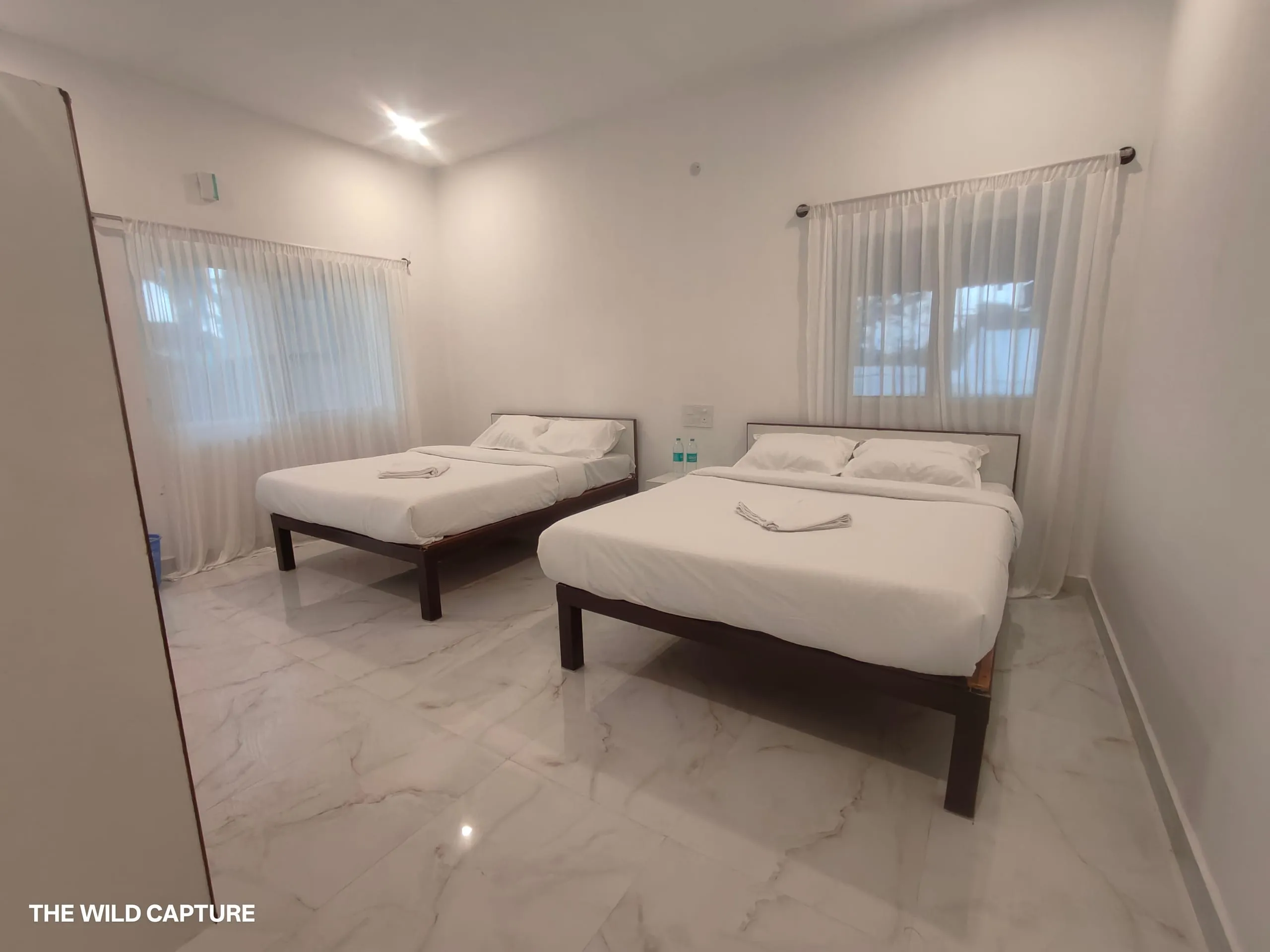 Plantation Room with a double and a single bed, sheer curtains and marble flooring